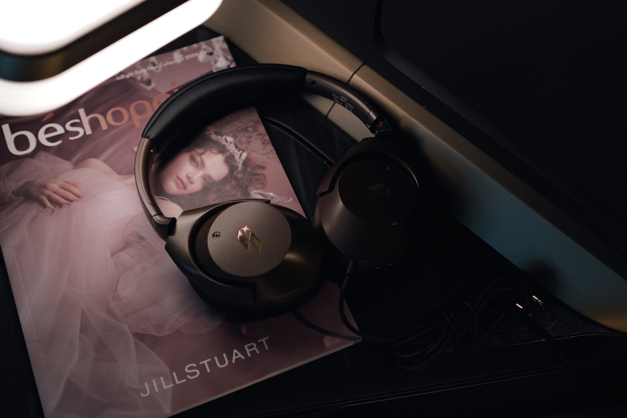beshop magazine and noise-cancelling headphones in STARLUX business class bed mode