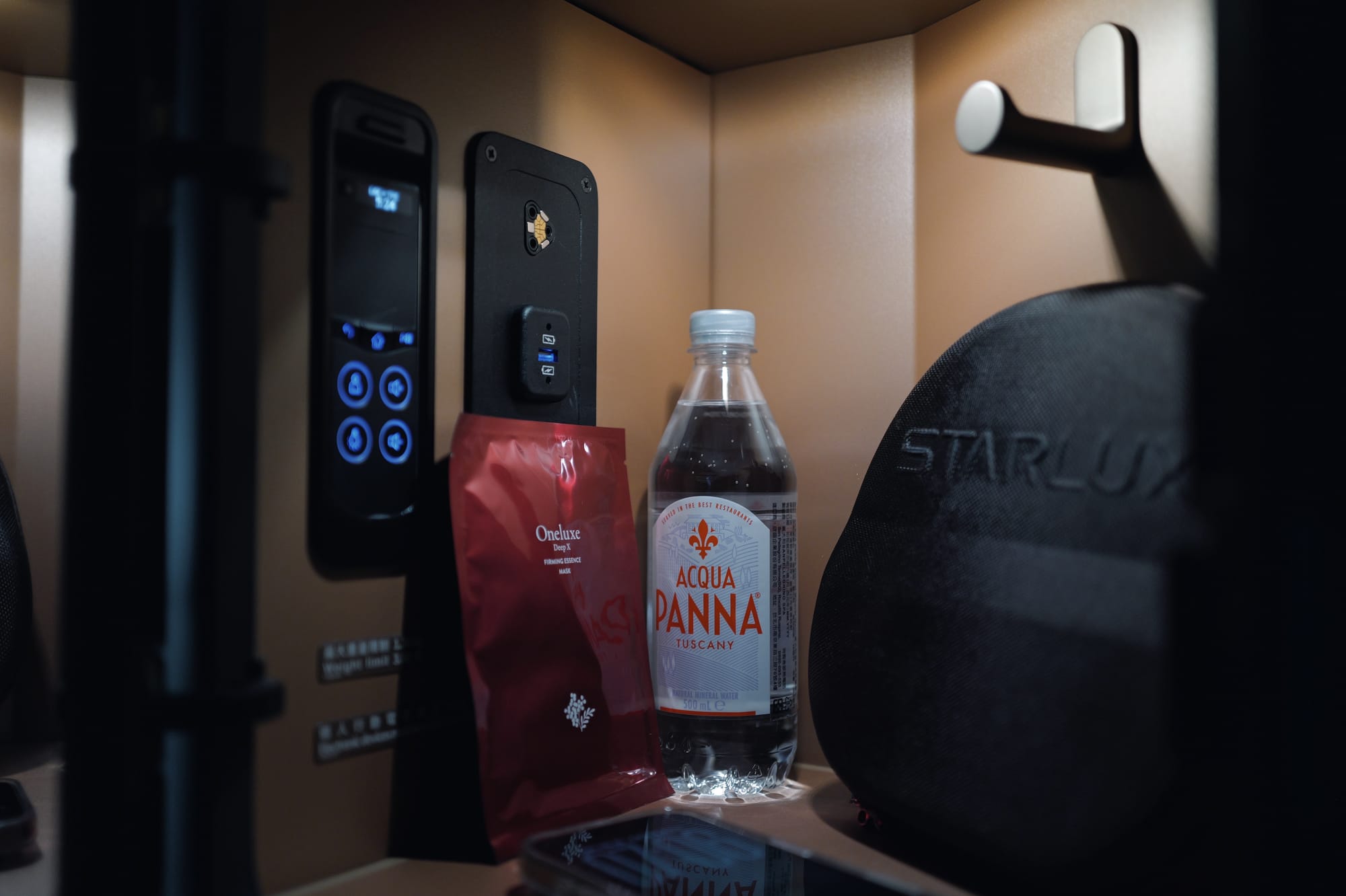 STARLUX A350 business class console with water, a snack and the airline headrest