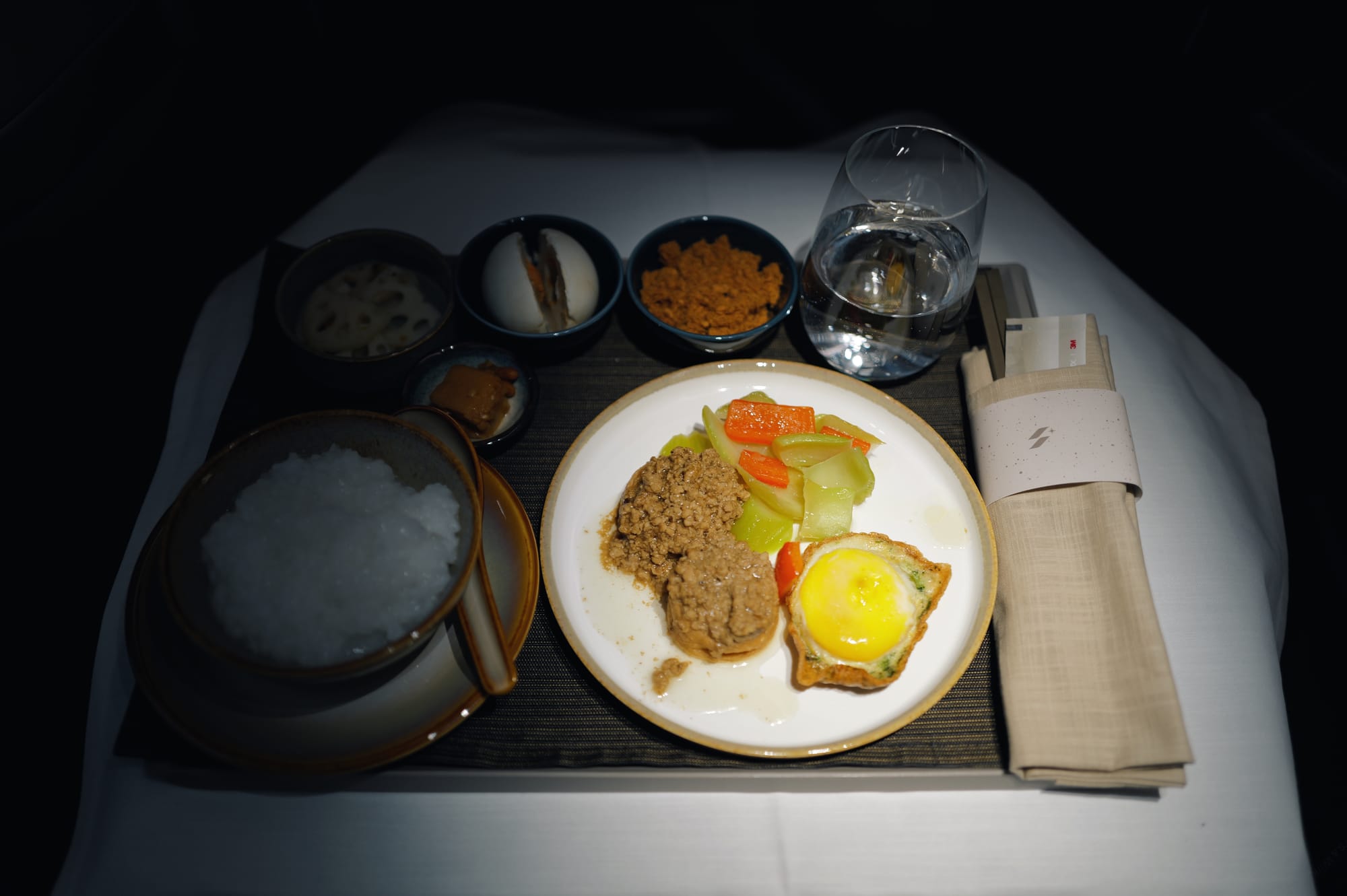 STARLUX business class breakfast of congee, egg and small sides on flight JX1
