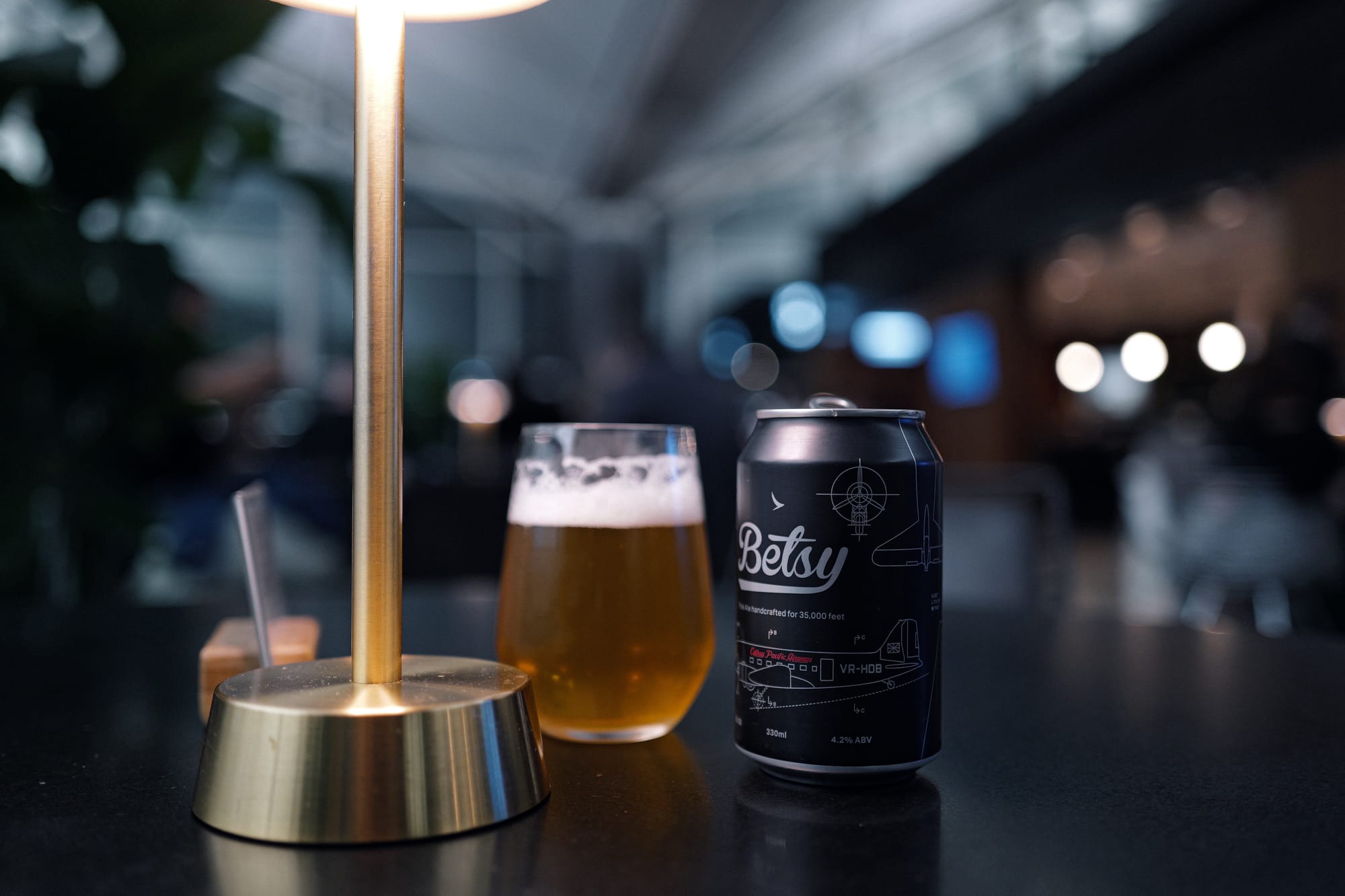 Betsy beer under a brass lamp at The Deck lounge, Hong Kong, before CX872