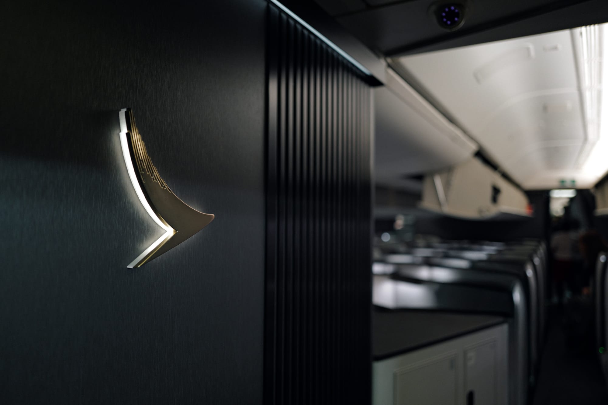 Backlit Cathay Pacific brushwing at the boarding door of the 777-300ER