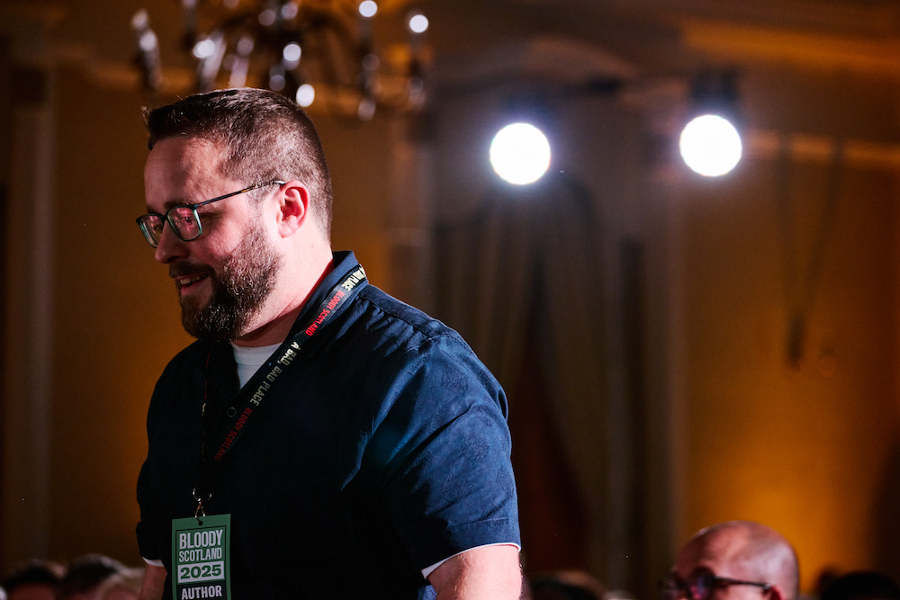 Me, in a blue shirt, under lights, walking up on stage, looking gobsmacked