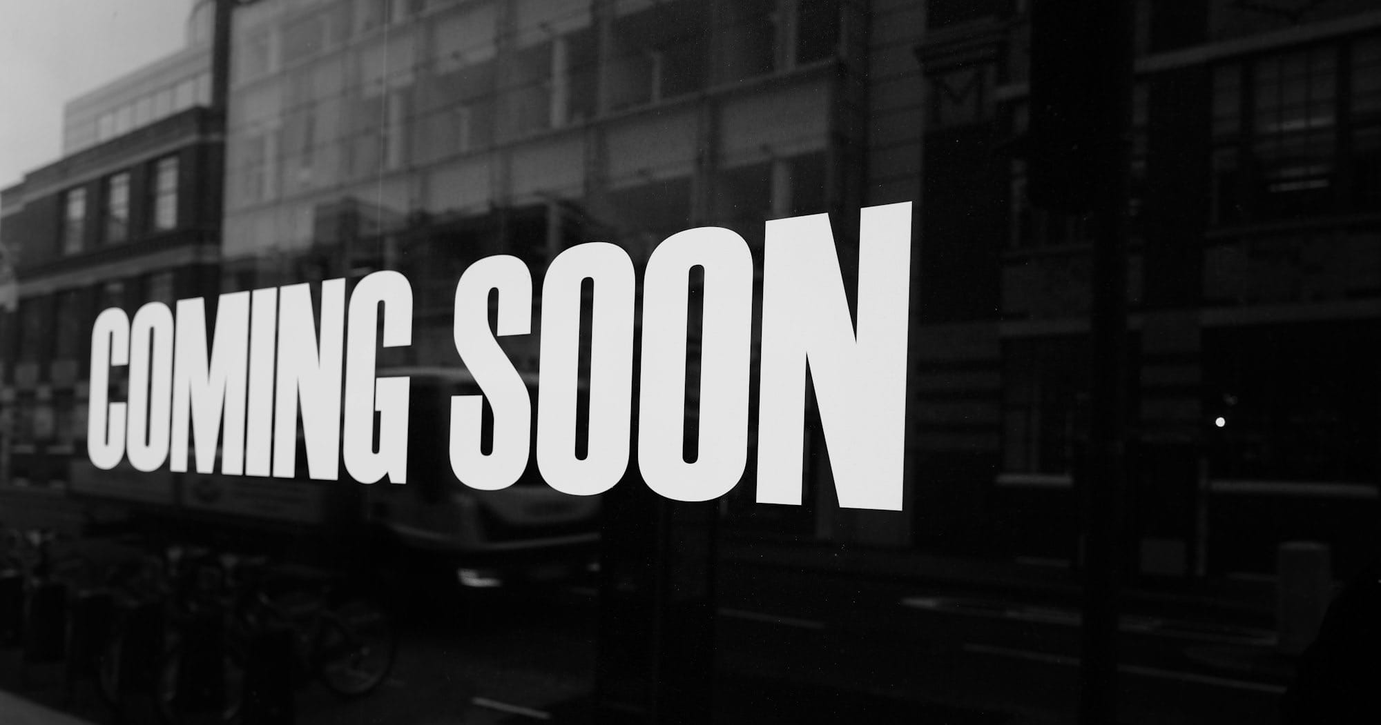 a black and white photo of a sign that says coming soon