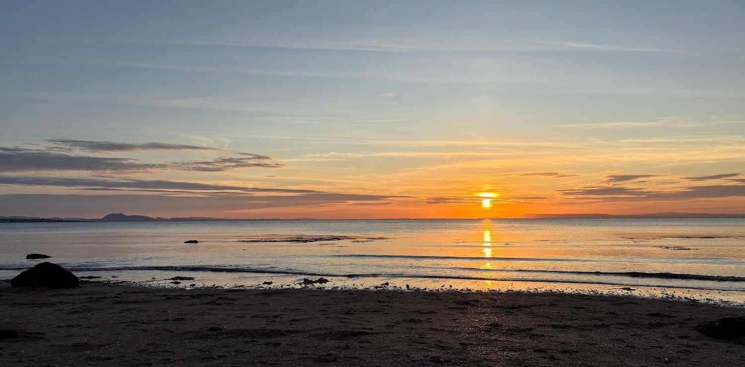 A view of a sunset from a beach in Scotland