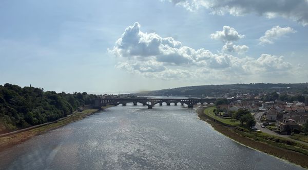 A view of a bridge, river and clouds from the southbound train to York