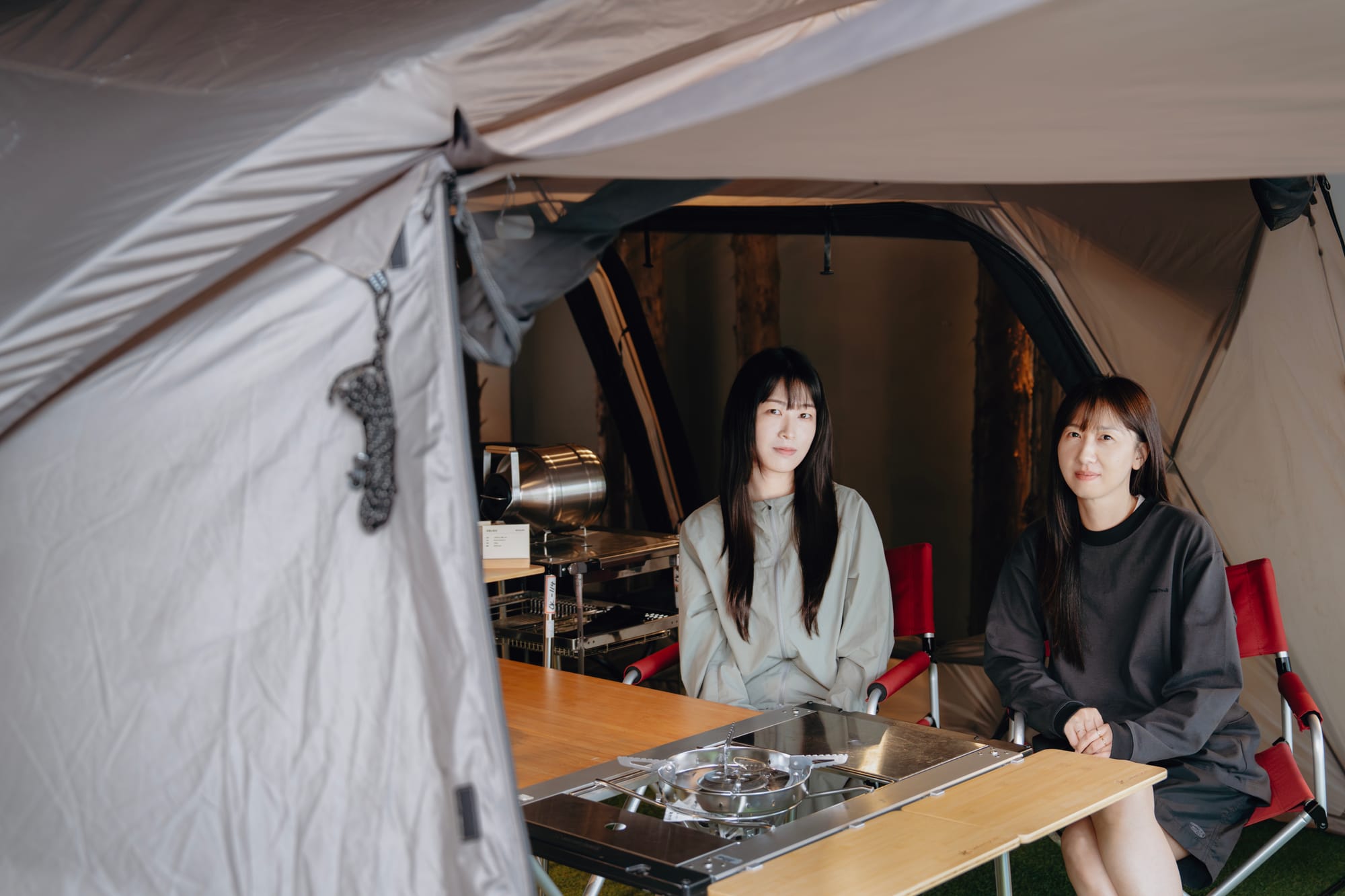 캠핑용 텐트 안에 앉아 있는 스노우피크 코리아 이민영·한재희 디자이너
