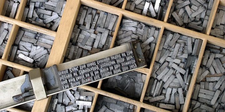 Letter types in a type case. The plate says "The quick brown fox jumps over the lazy dog and feels as if he were in the seventh heaven of typography together with Hermann Zapf.