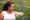 An overweight woman looks at her watch before running