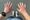 A runner looks at her swollen hands after running a half marathon