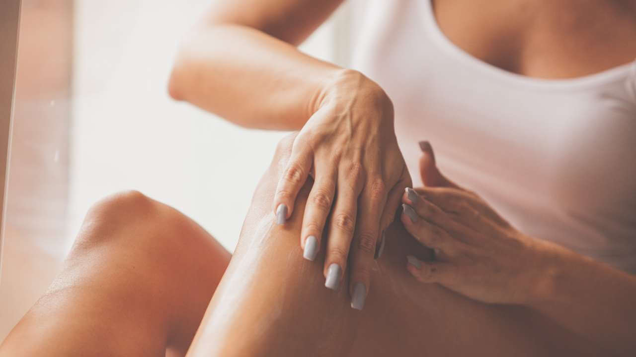 Woman using bleaching creams and home remedies in circular motions to lighten dark knees by removing dead skin cells. 