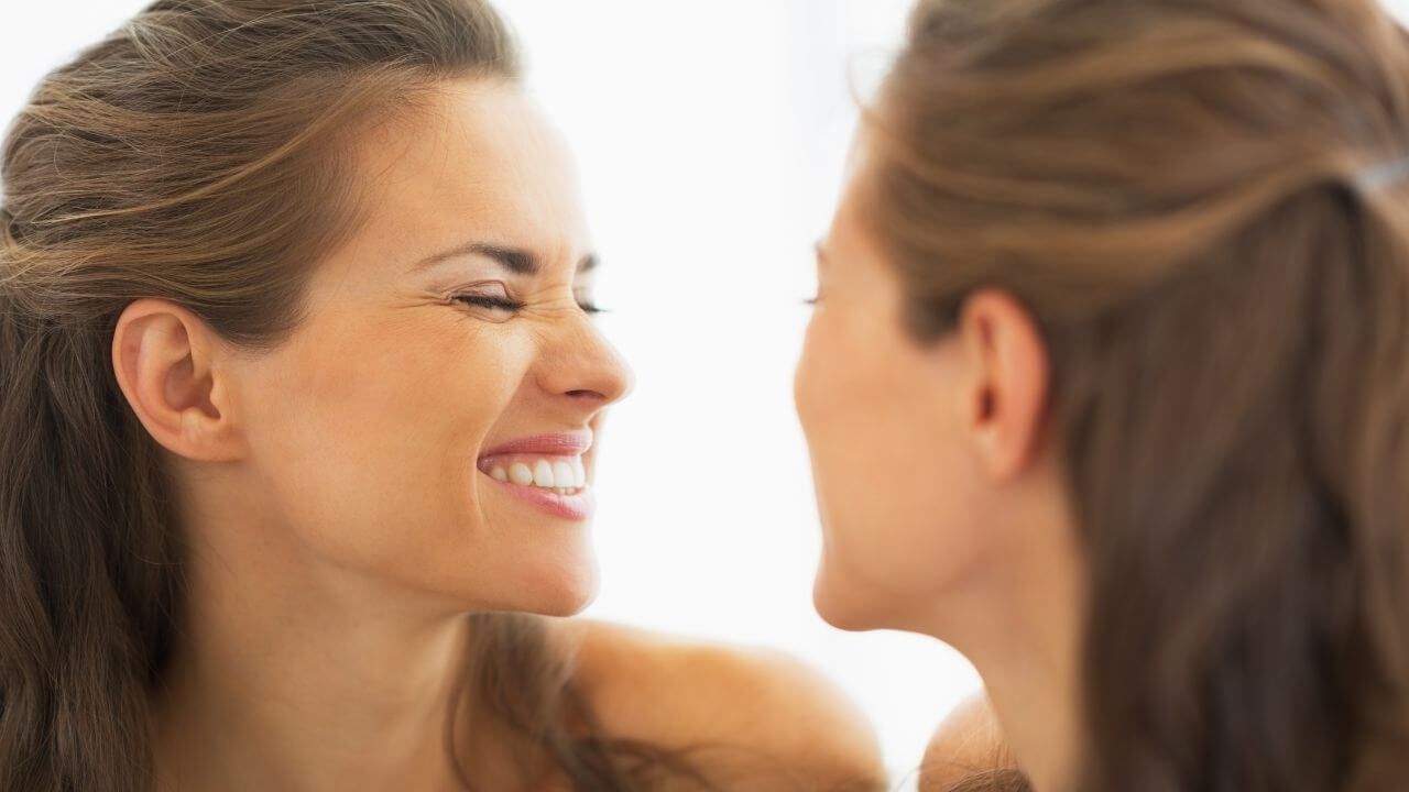 Woman smiling, illustrating how dynamic lines and wrinkles form when making a facial expression. 