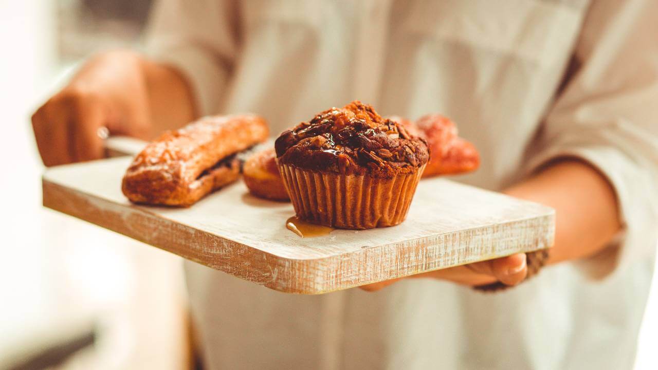 A person serving muffins and quick breads made with collagen powder.