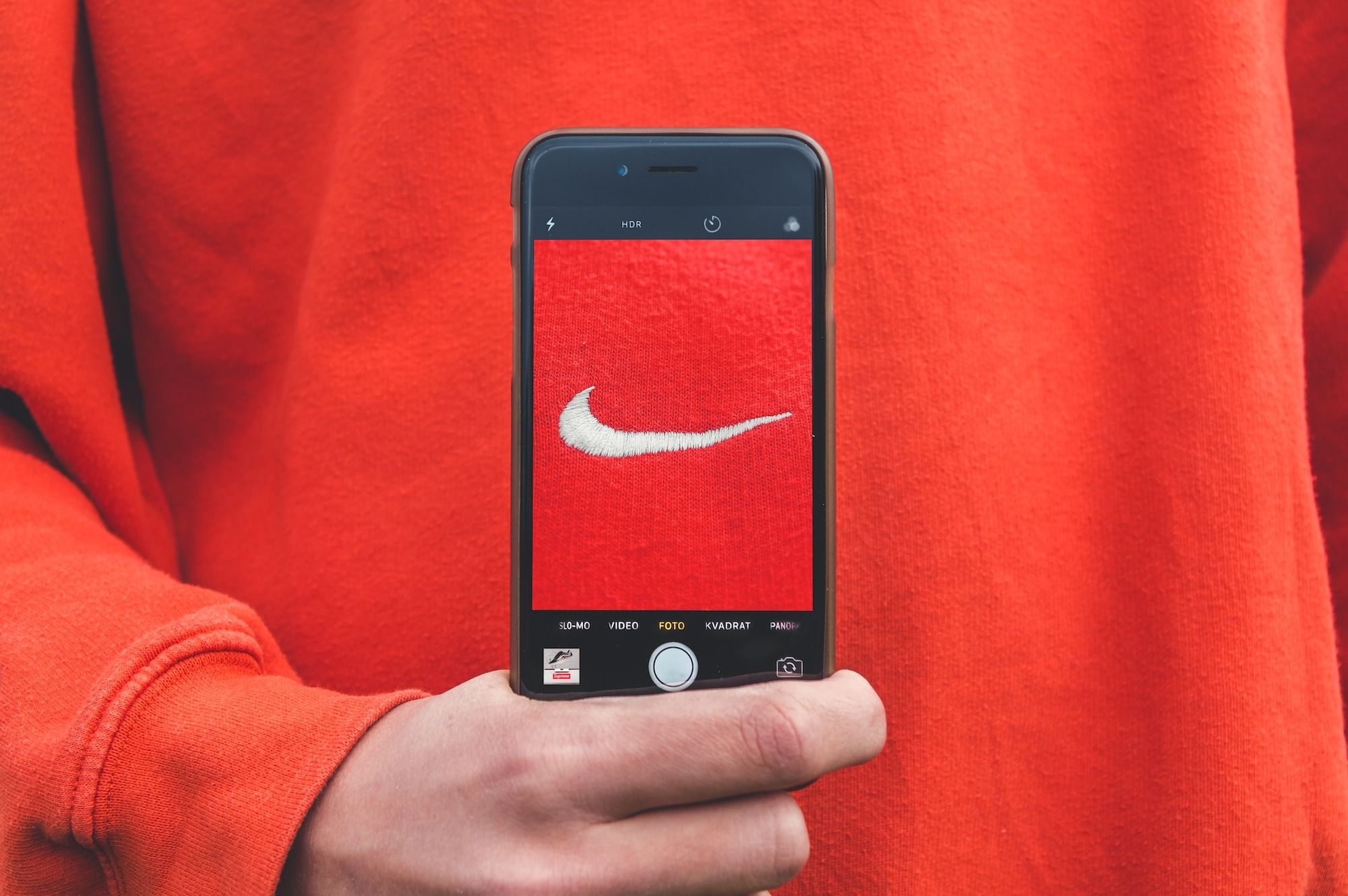person holding iPhone taking picture on Nike label