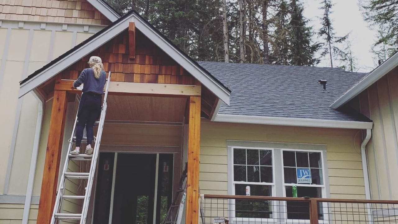 A person painting a wood wall
