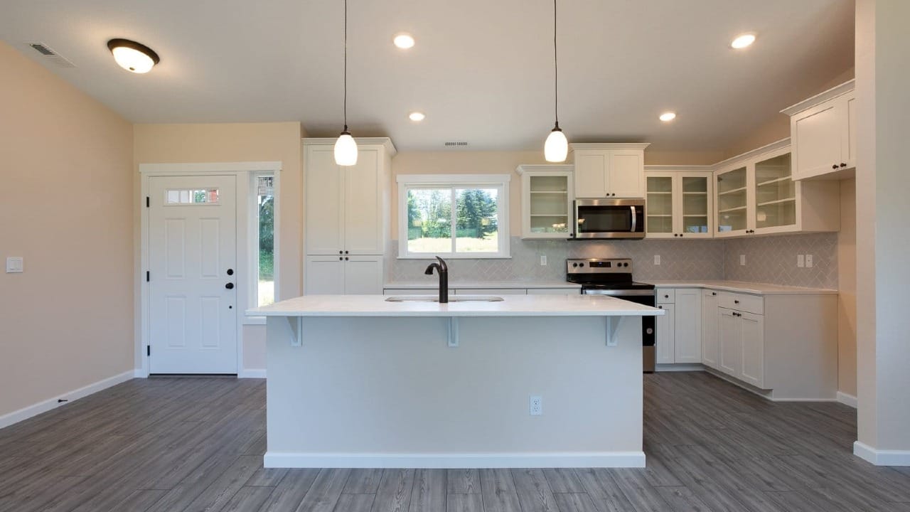 A kitchen with a sink and white cupboards