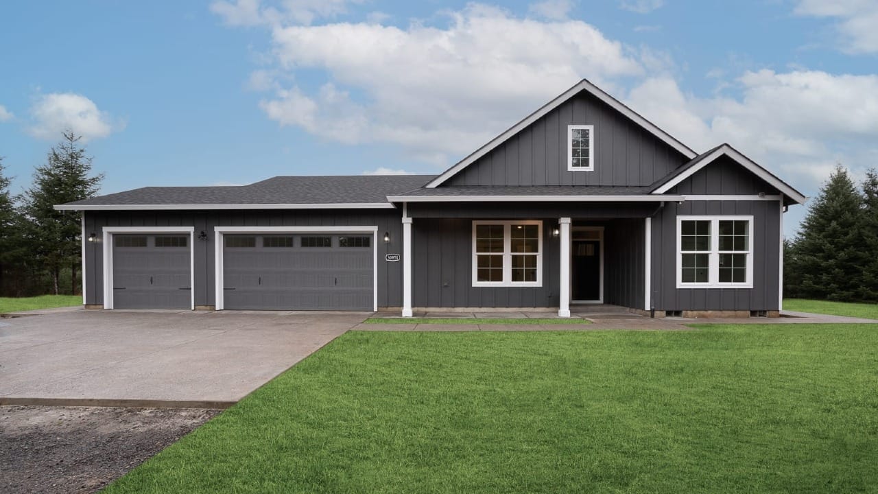 A dark grey house underneath a blue sky