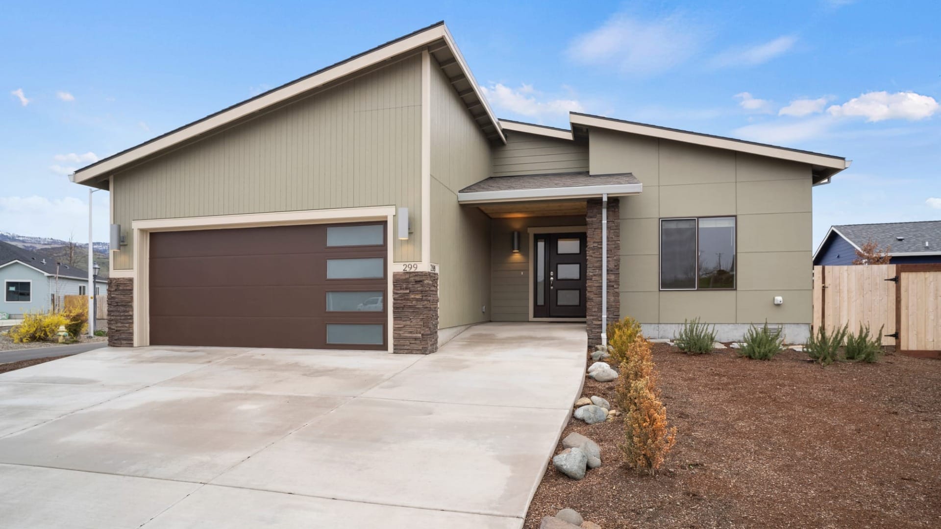 A tan house with a concrete driveway