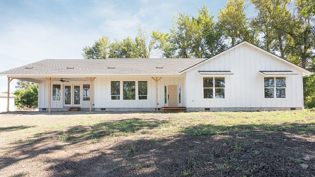 A white house in front of a bunch of trees