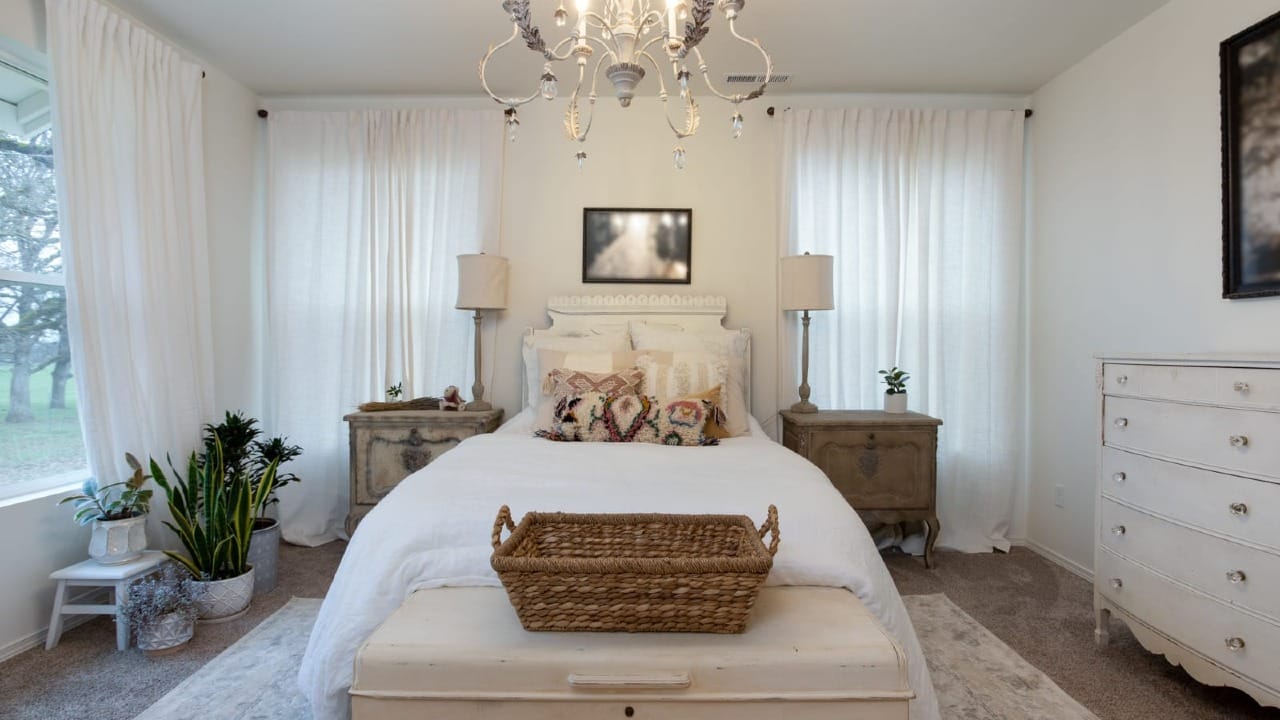 A master bedroom with a basket in front of the bed