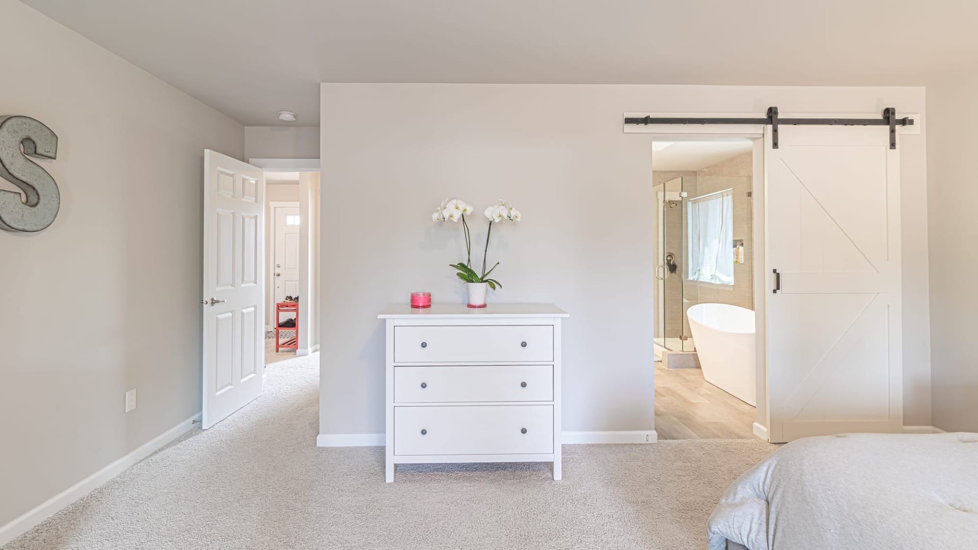 A bedroom with a bathroom connected to it