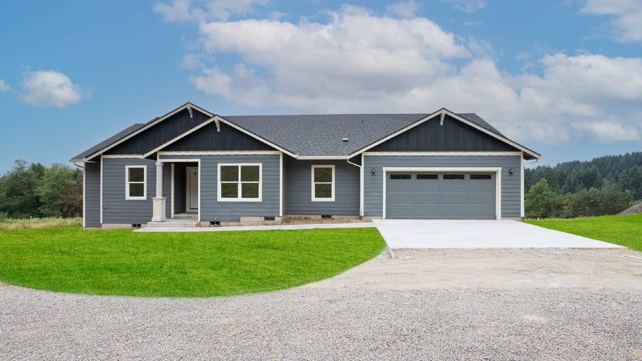 A blue house in front of a green yard