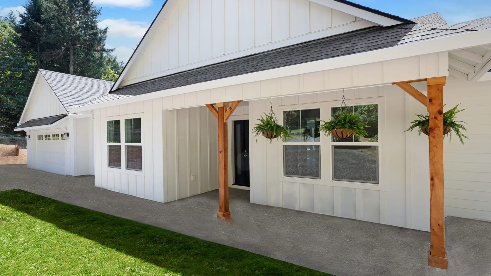 A white house with wooden pillars in fornt of a green lawn