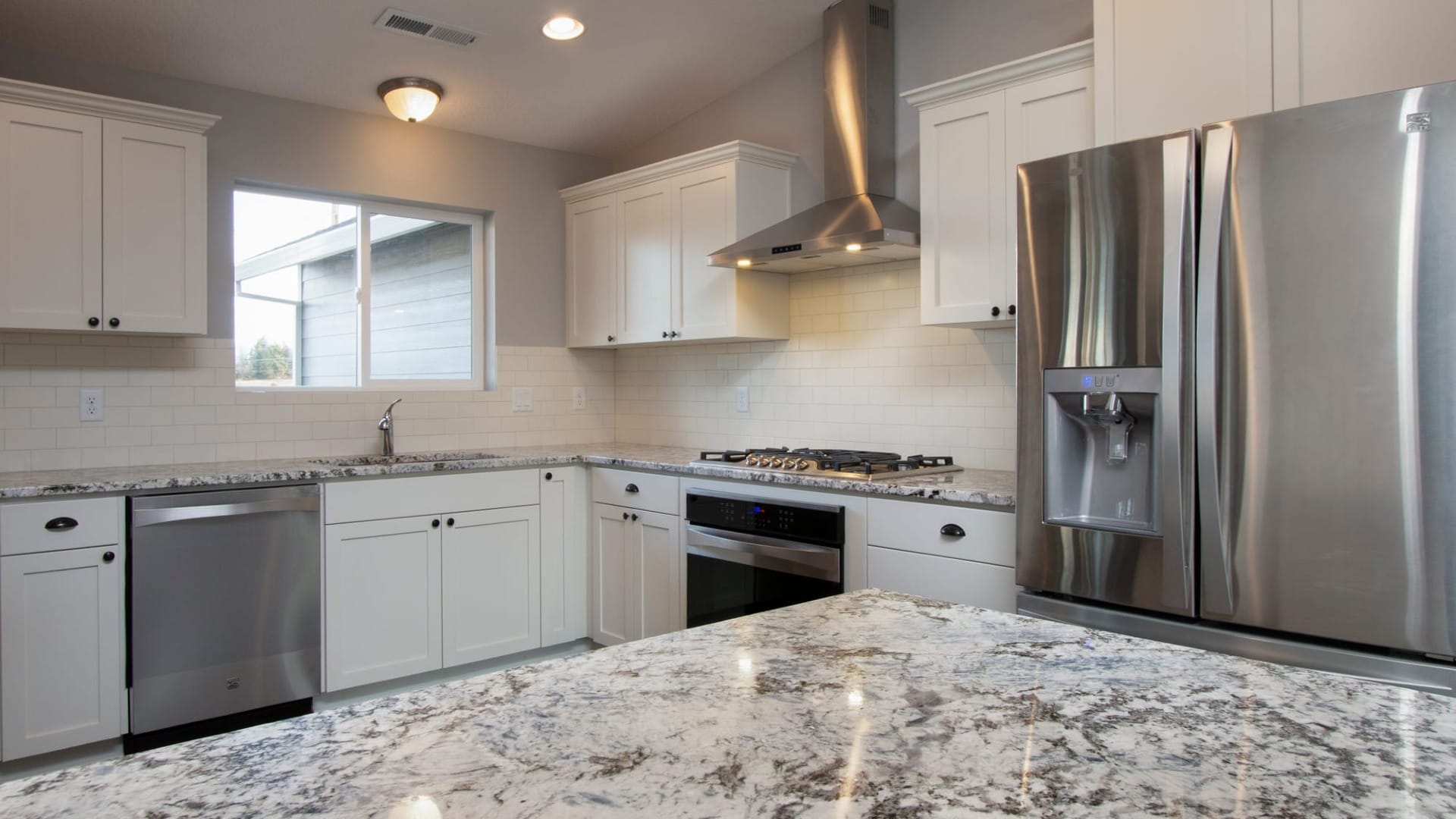A white kitchen with a granite countertops