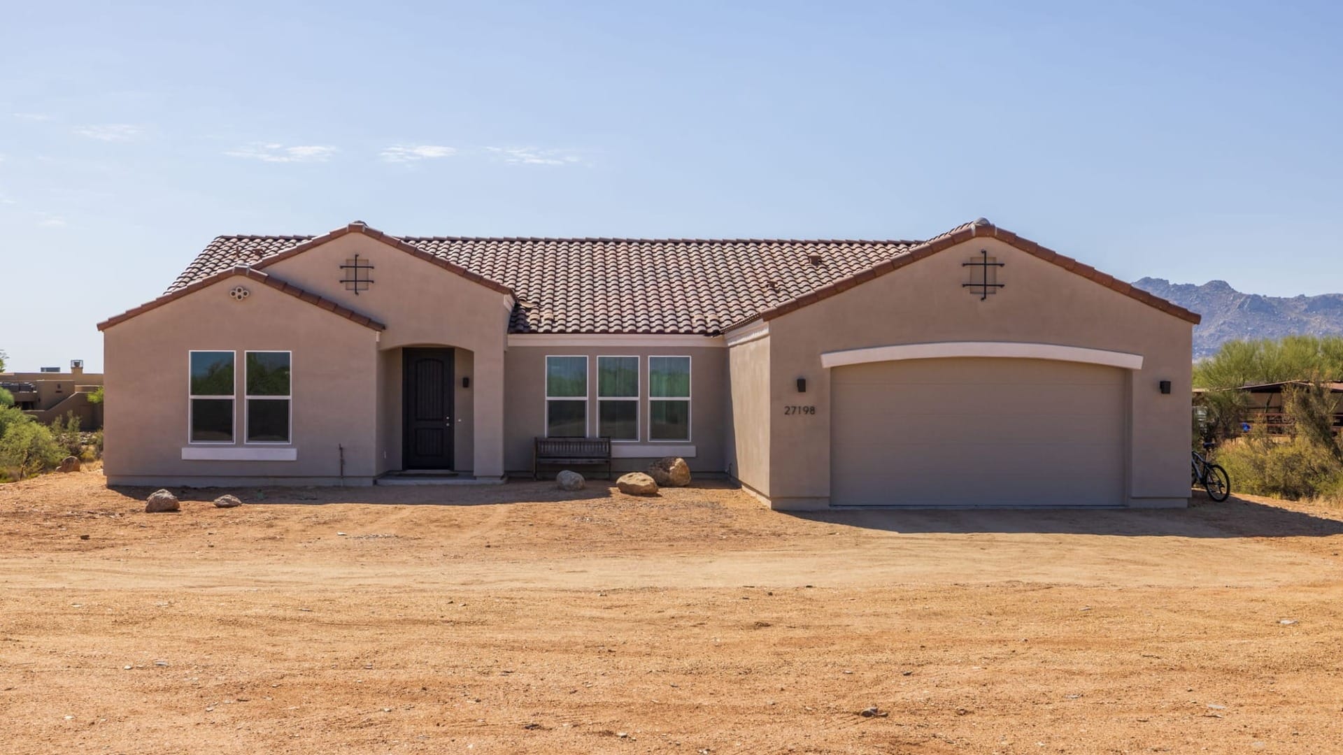 A house in Arizona with Stucco siding surrounded by dirt