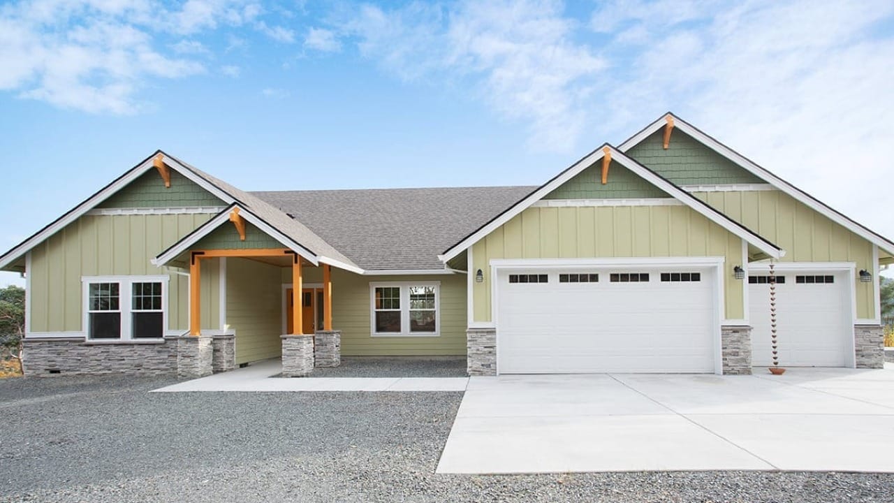 A house with green siding and a stone foundation
