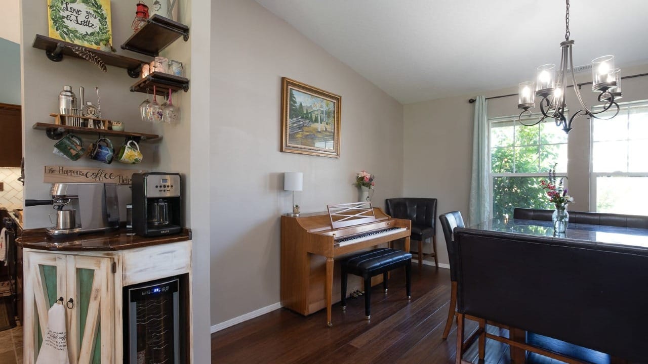 A dining room with a piano next to the wall
