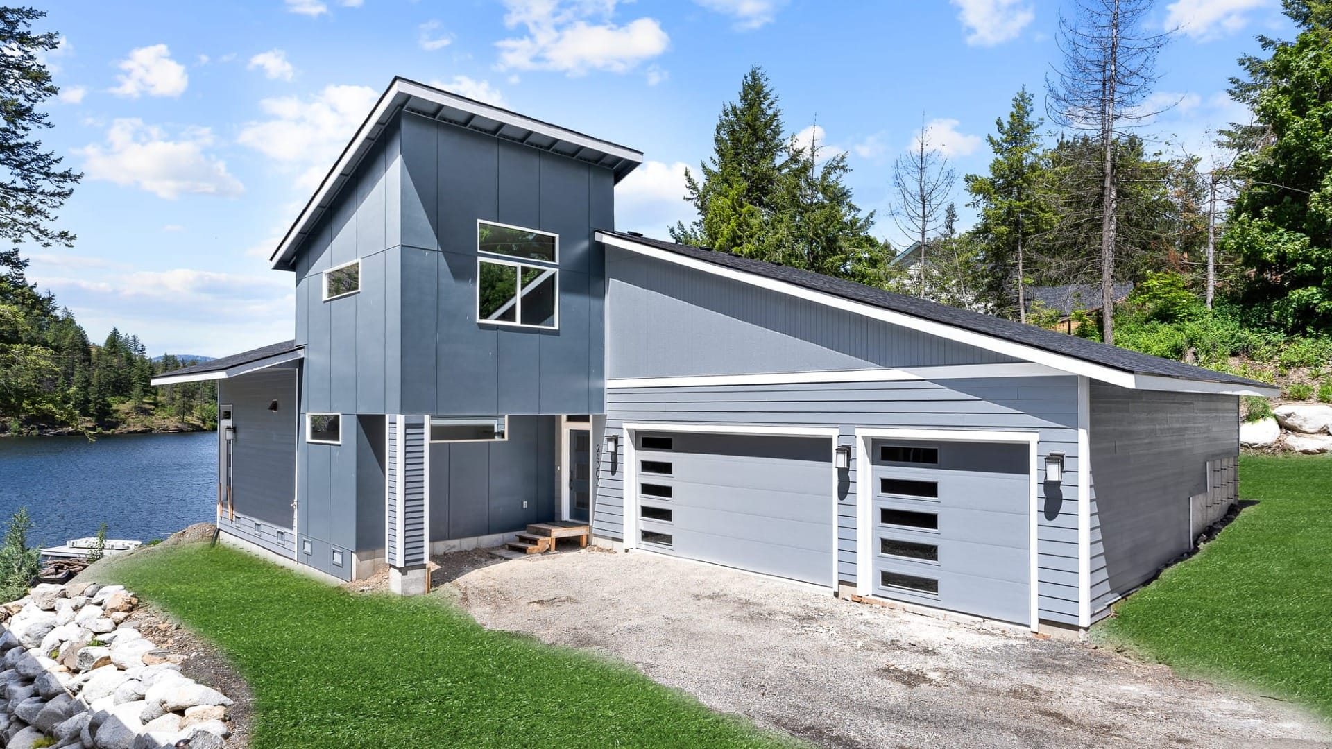 A blue house painted with Sherman Williams paint next to a lake