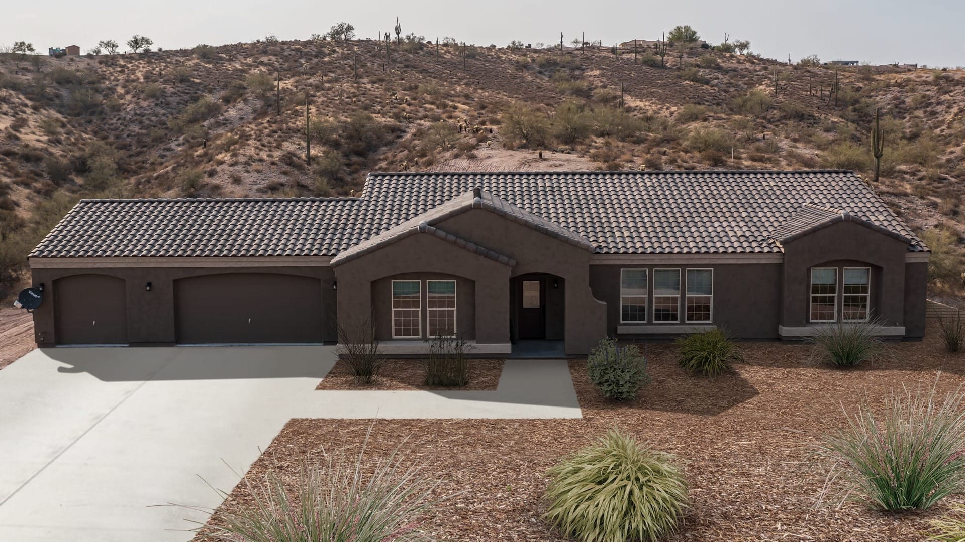 A house with brown Stucco Siding in Arizona on a desert plot of land