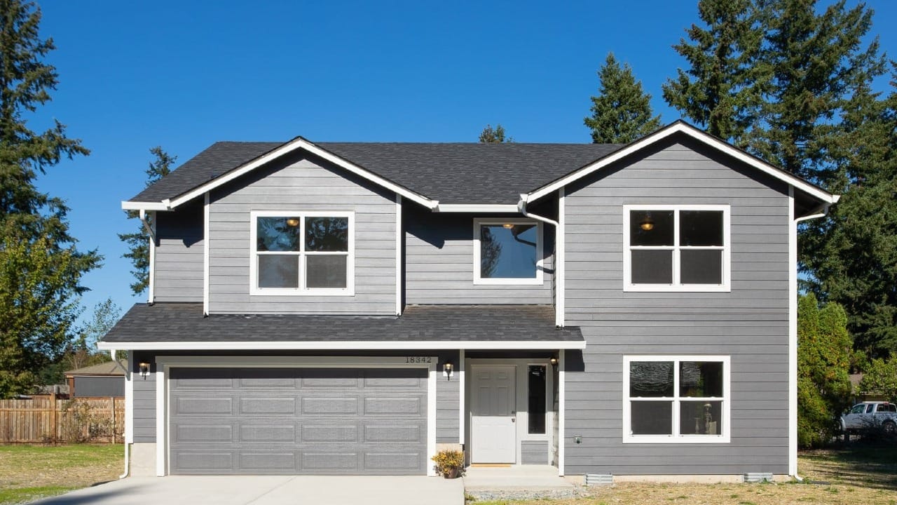 A grey home with a concrete driveway