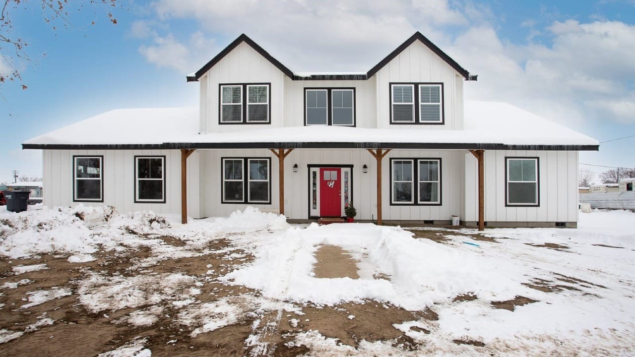A white house with snow in front of it