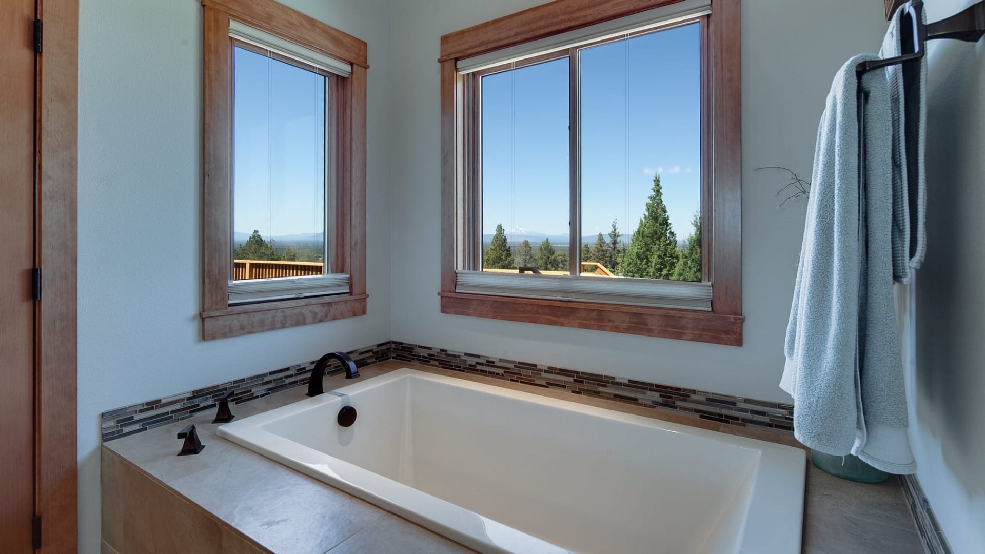 A bath tub next to some nice windows