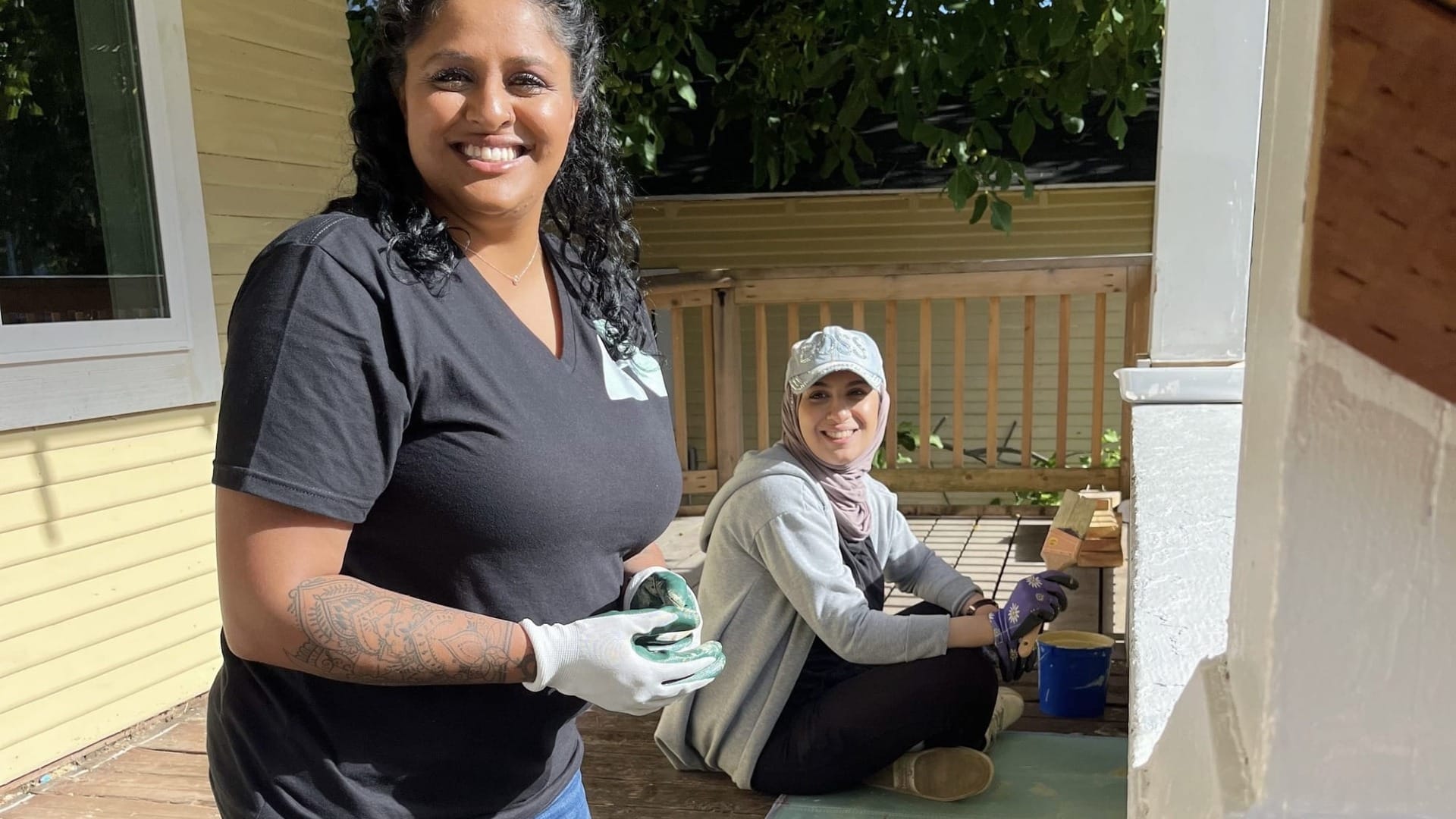 A couple volunteer workers helping with painting a house