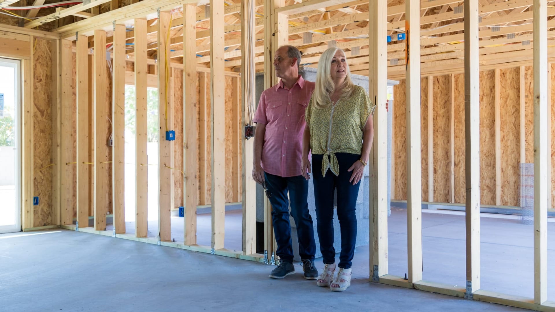 A couple looking into the frame of their house they are building