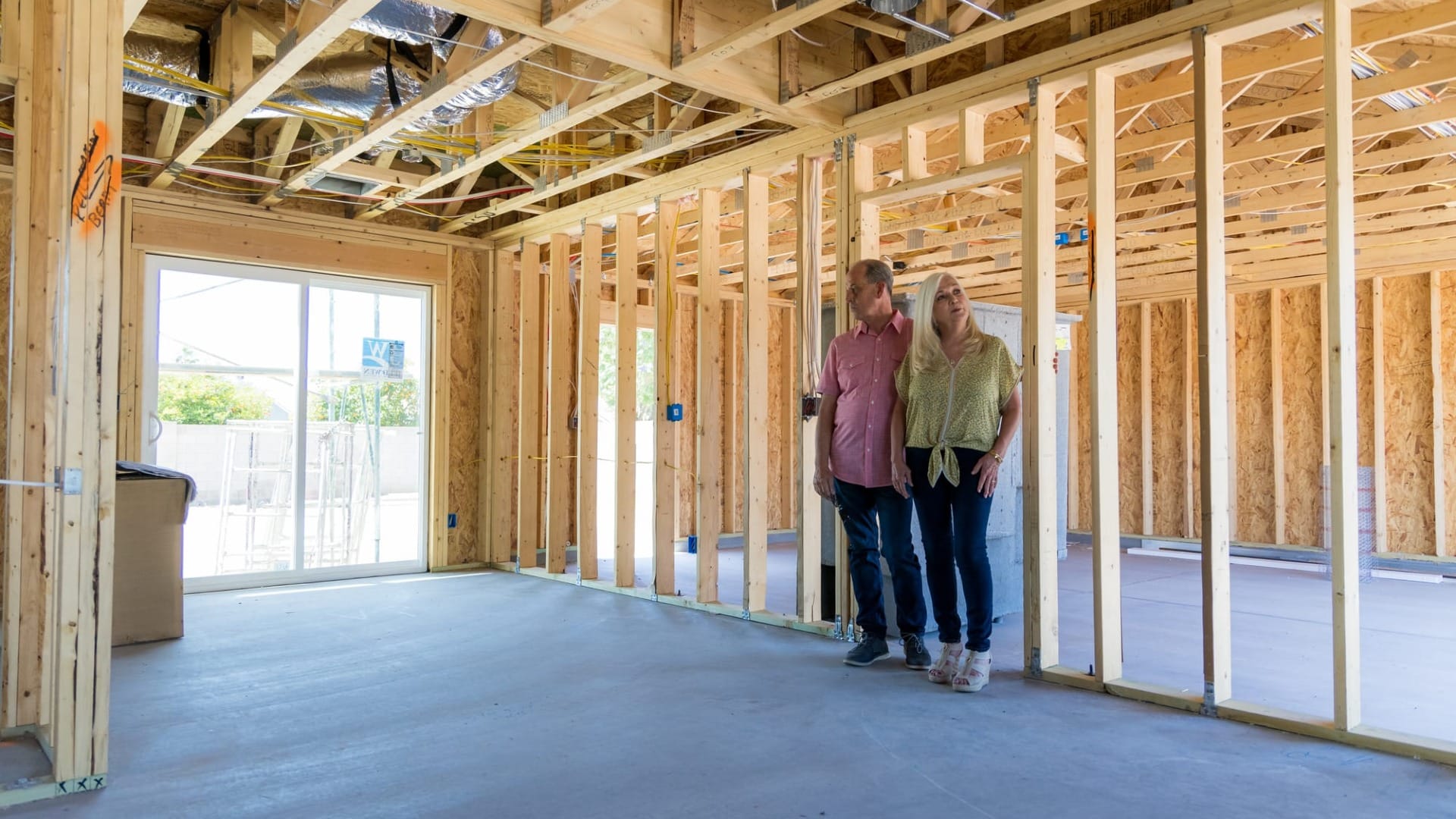 A couple taking a look at their home that is just wood