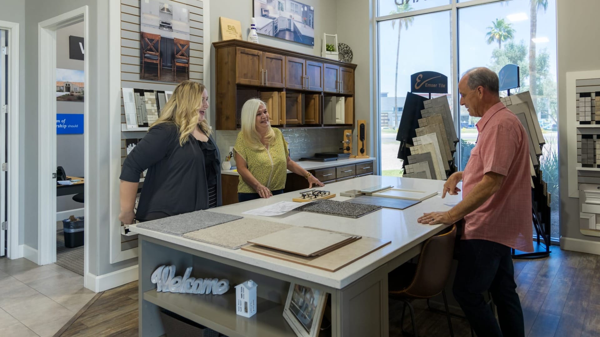 Homeowners meeting with Adair Homes team at a design center reviewing material samples and finishes for a custom home.