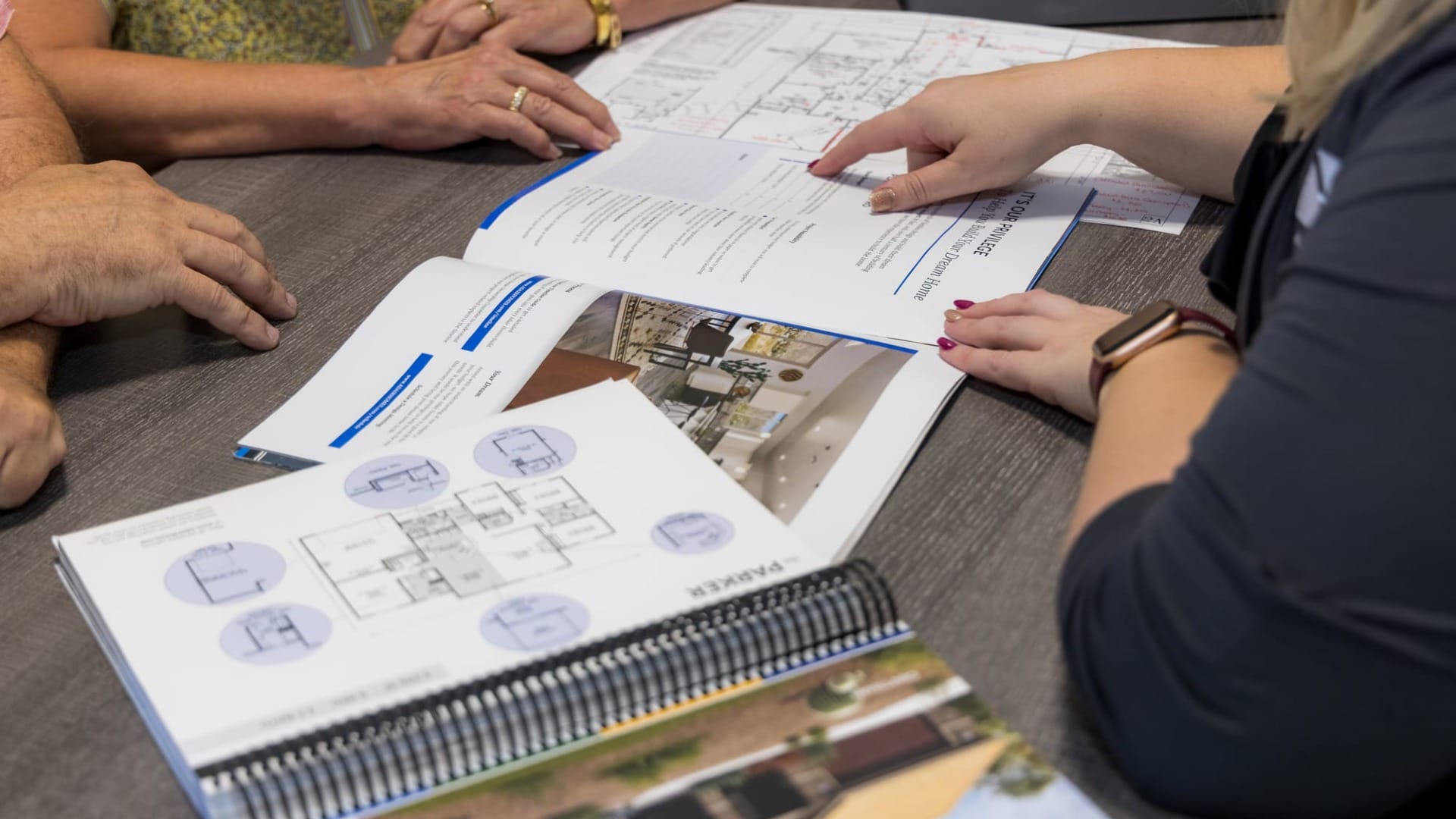 People taking a look as some blueprints for a house