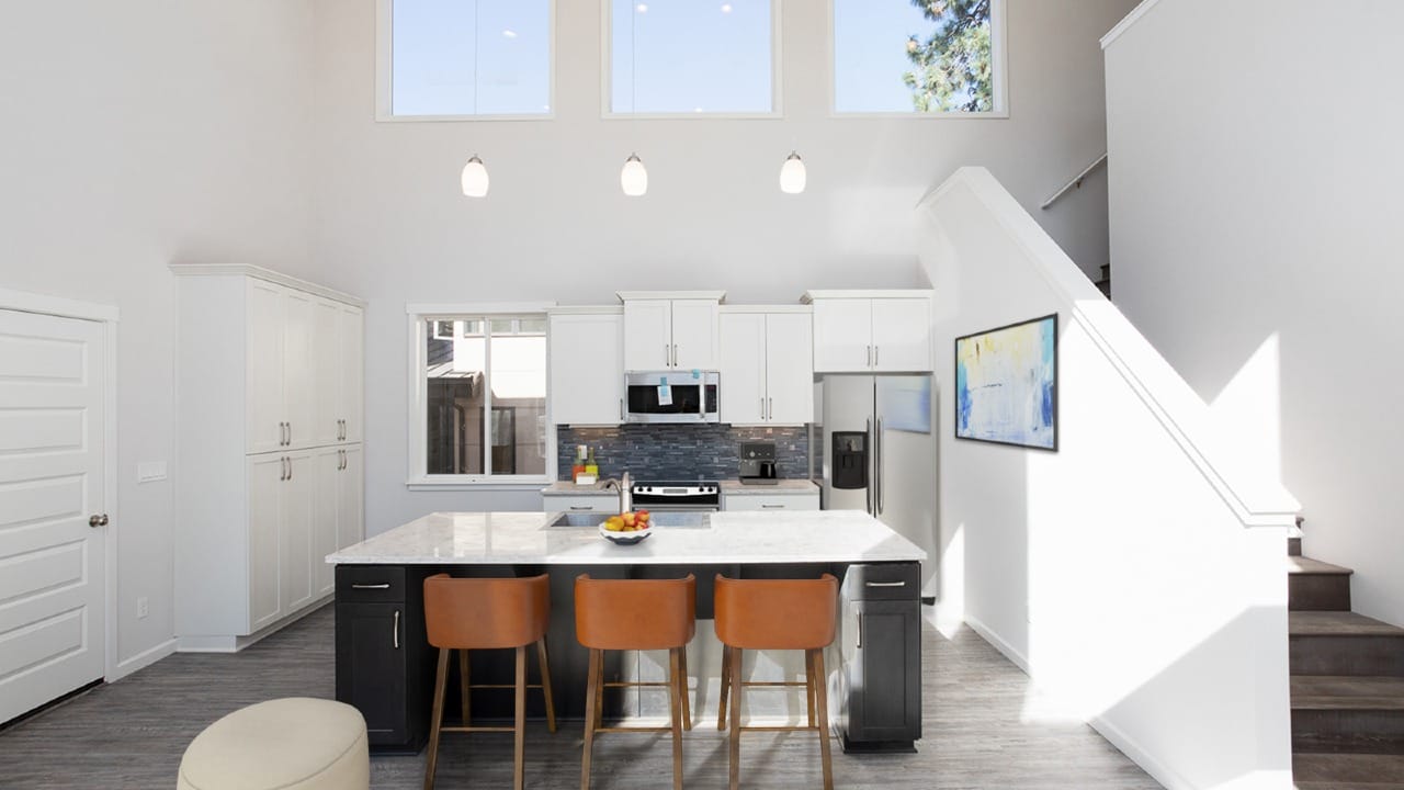 A dining room and kitchen area with a staircase to the right