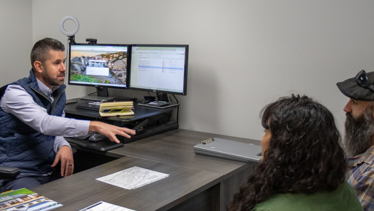 A man talking to a couple about a new house