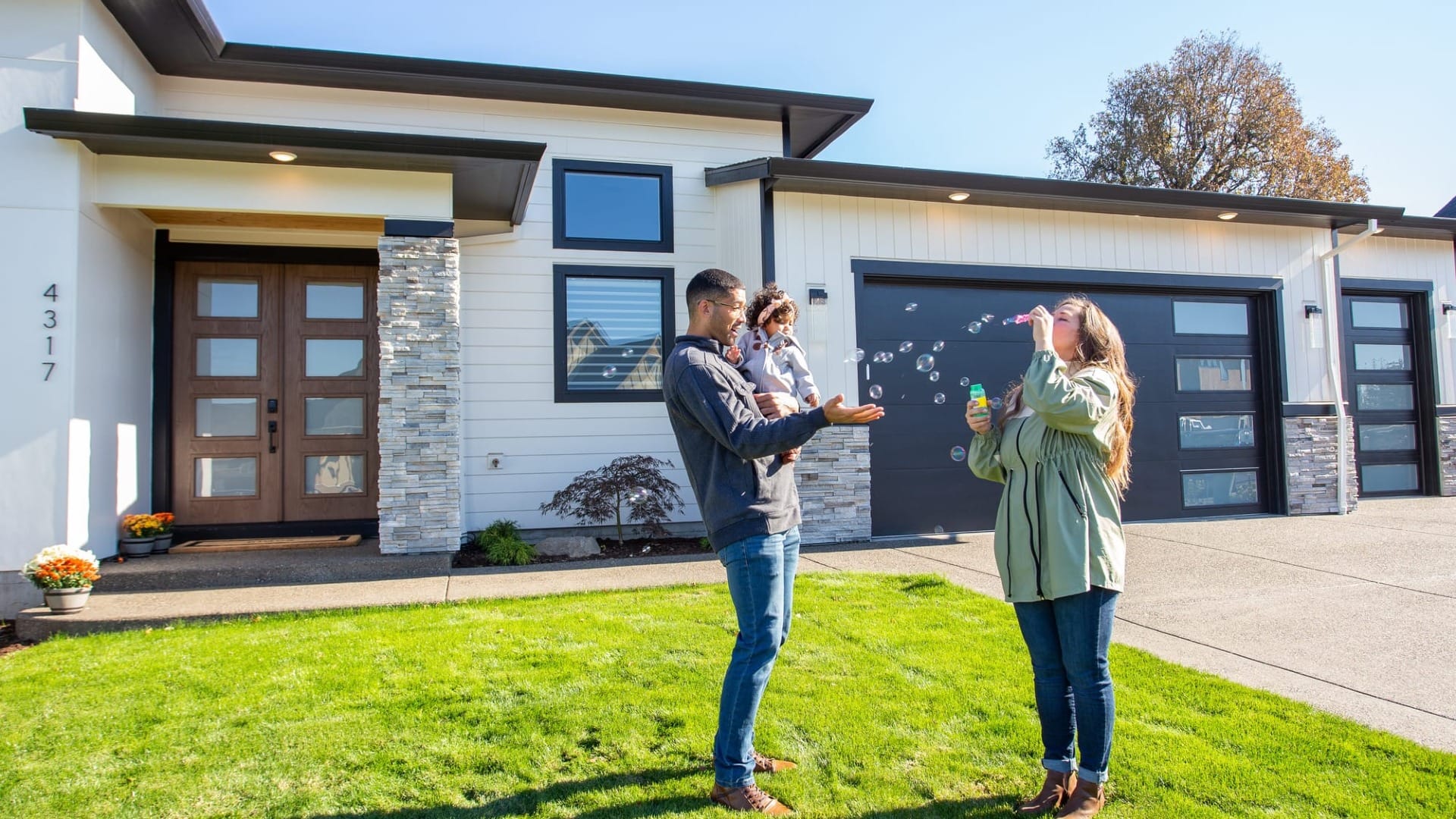 A lady blowing bubbles in her front yard