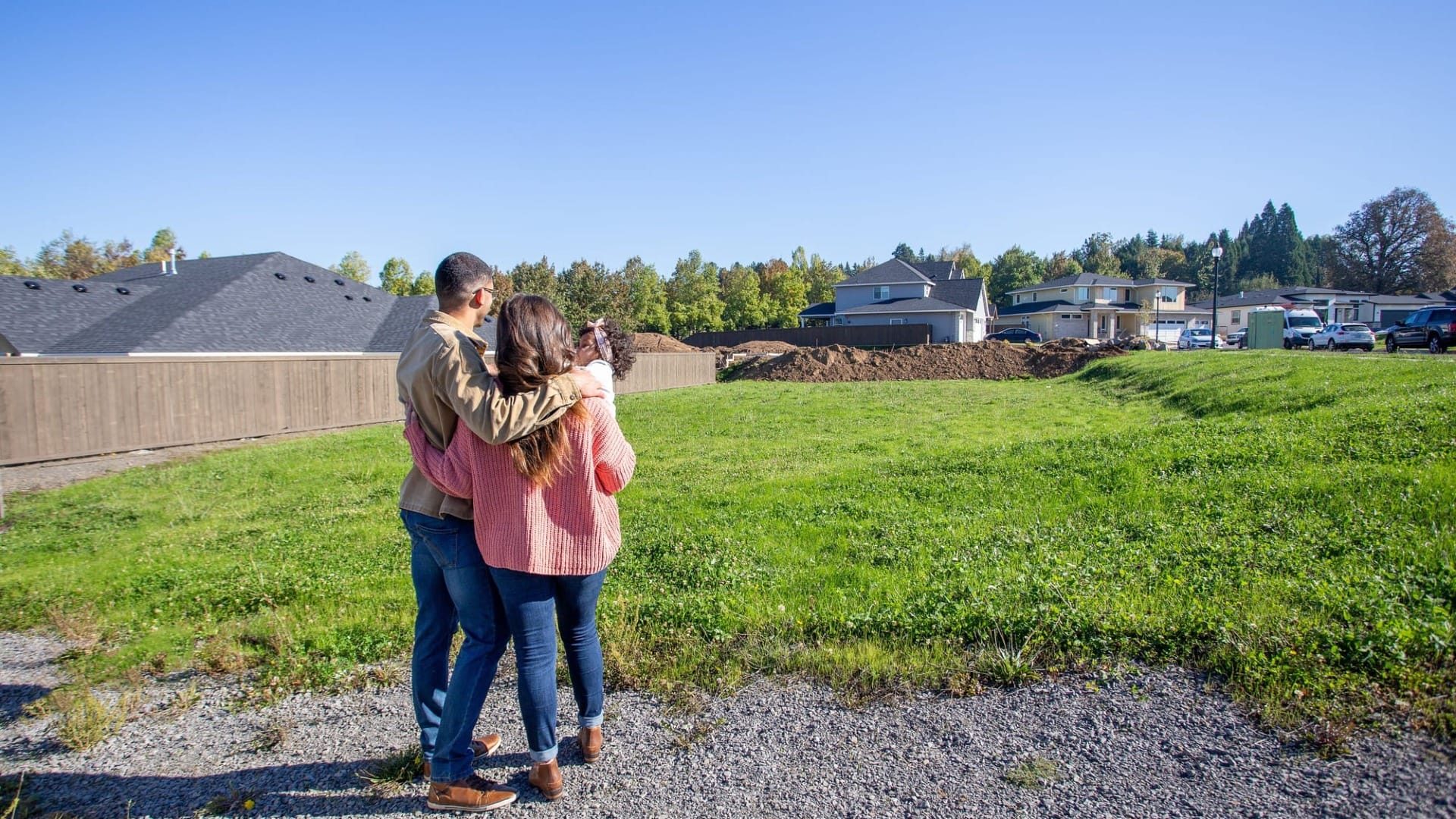 A couple looking at the plot of land that their house will be built on