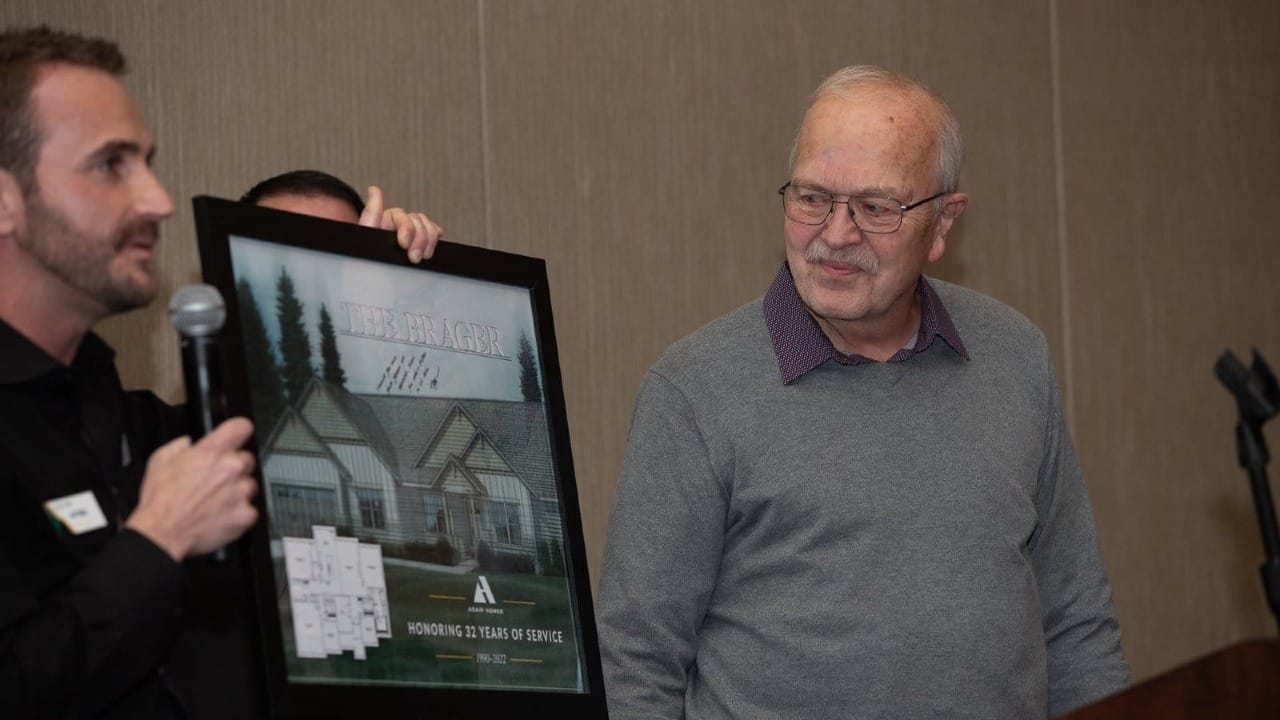 man holding a picture of the brager home plan
