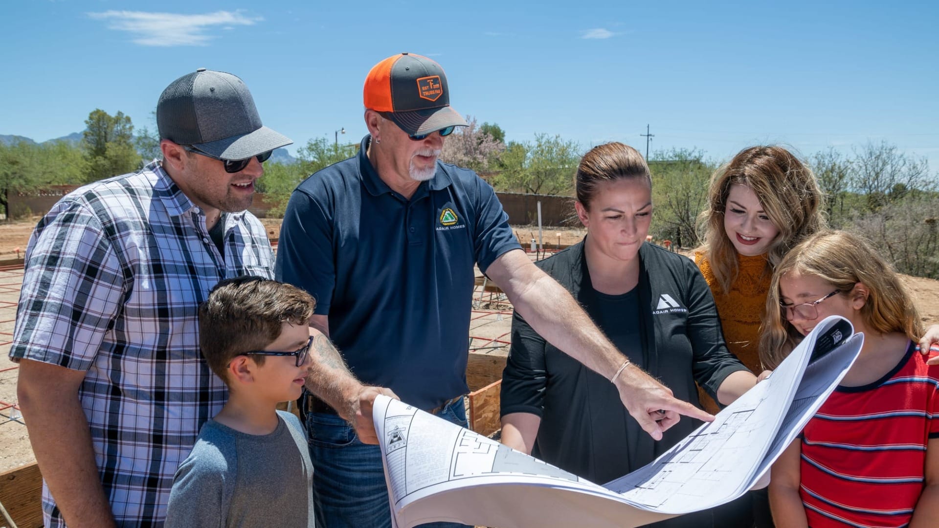 A family looking at the blueprints of their home being built