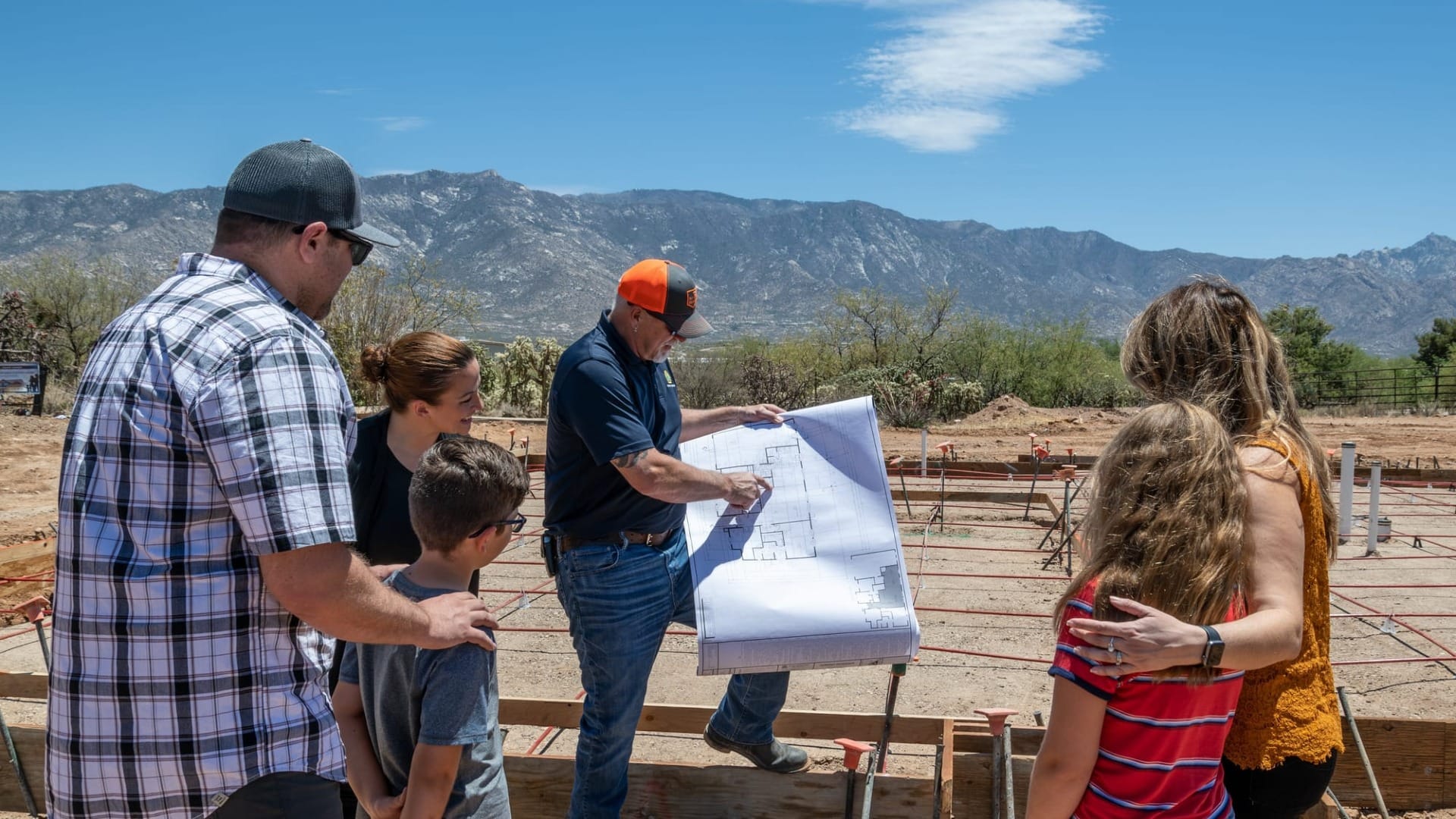A family looking at a blueprint of their house being built