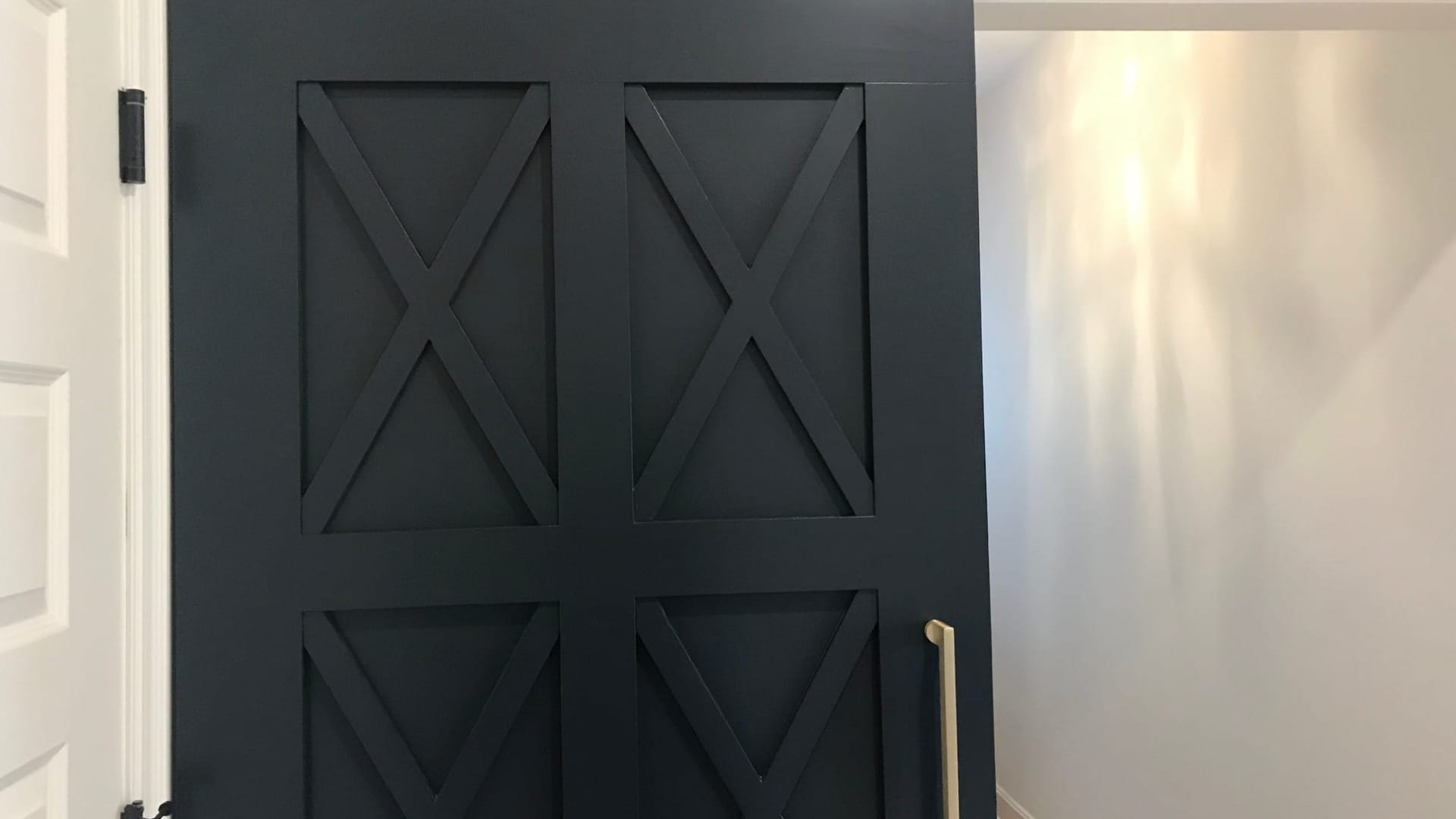 A black door in front of a hallway
