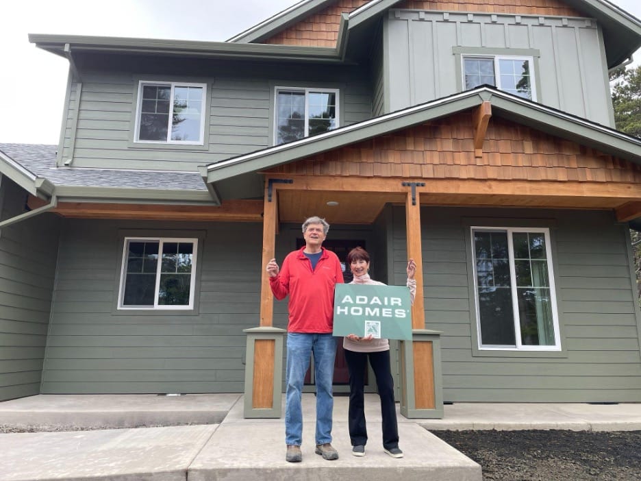 couple standing in front of their new home made by Adair Homes