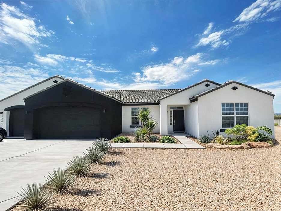 Single-story ranch-style Adair custom home with a tile roof, desert landscaping, and a bold black-and-white exterior contrast design.